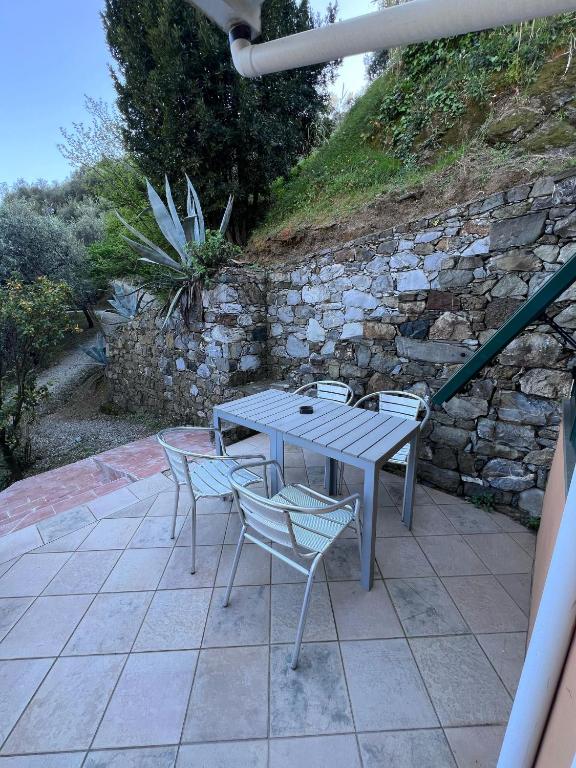 a table and chairs on a patio with a stone wall at Agriturismo Buranco in Monterosso al Mare
