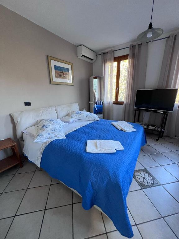 a bedroom with a blue bed with towels on it at Agriturismo Buranco in Monterosso al Mare