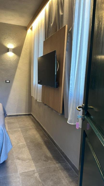 a room with a tv on a wall with a window at Agriturismo Buranco in Monterosso al Mare