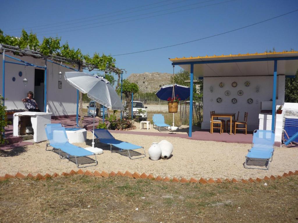 a playground with blue chairs and an umbrella at Haraki Vineyard in Haraki