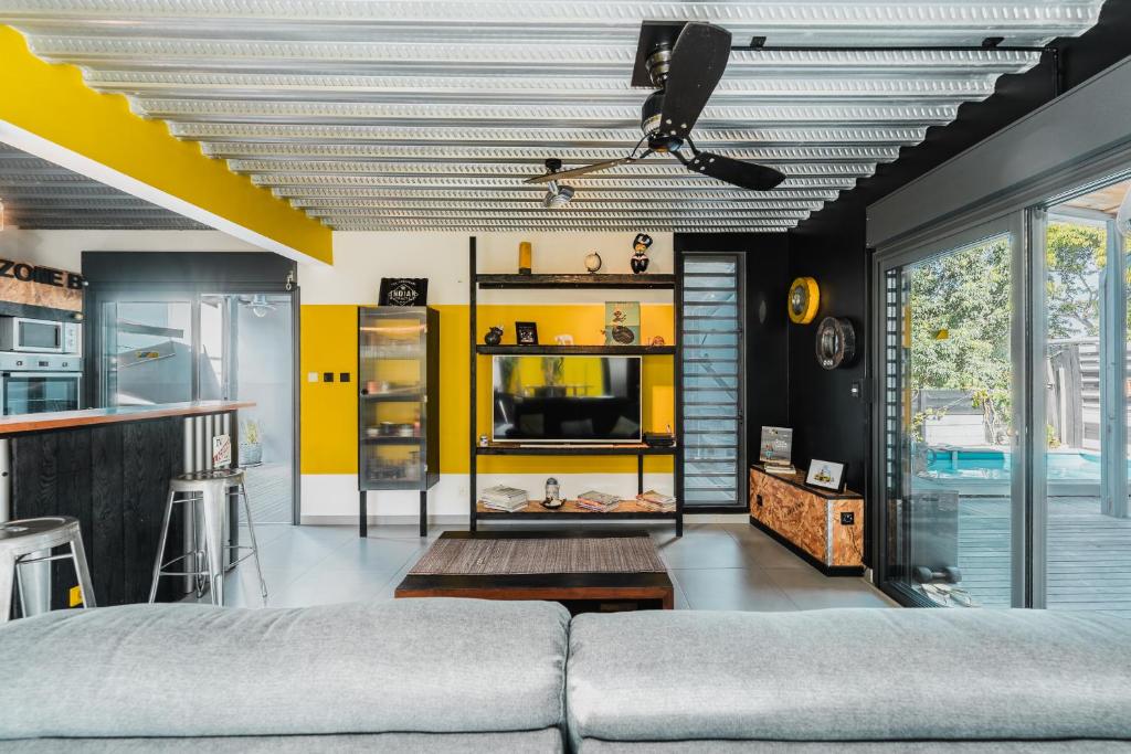a living room with a couch and a yellow wall at Factory in Saint-Pierre