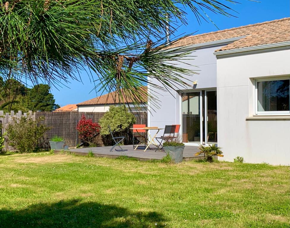 a house with a table and chairs in the yard at Maison familiale avec jardin a deux pas de l'océan in Préfailles