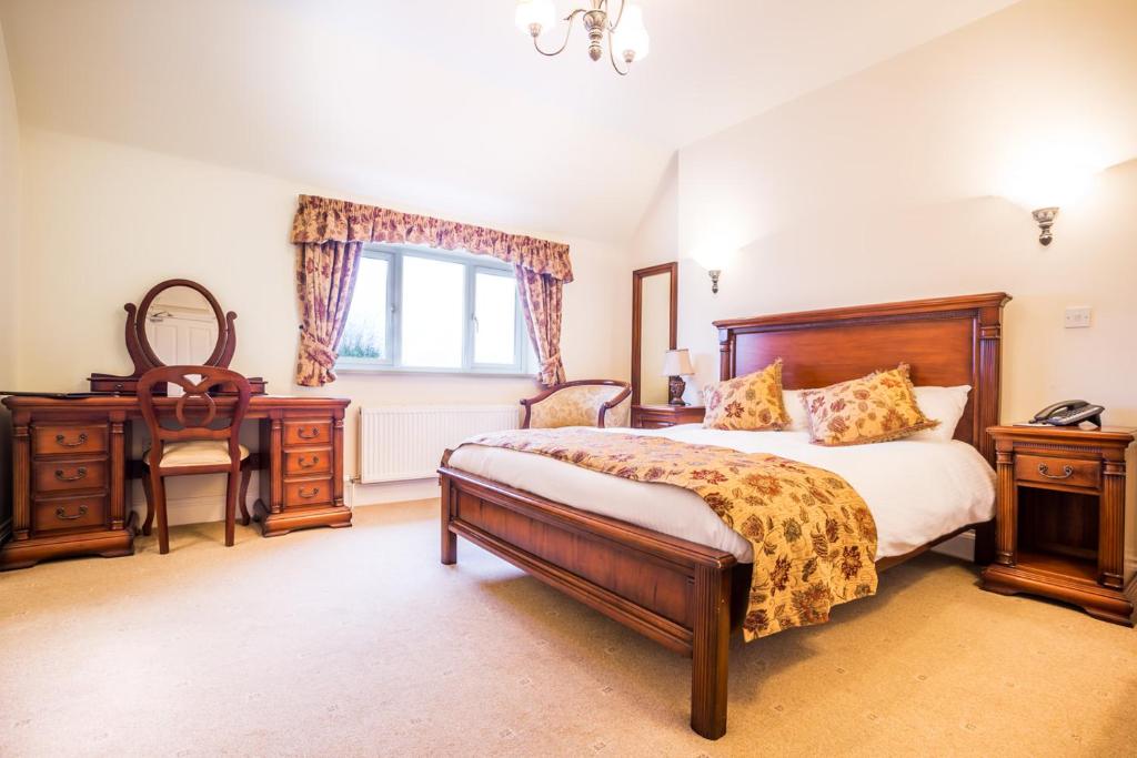 ブリッジノースにあるThe Down Innのベッドと机と窓のある寝室