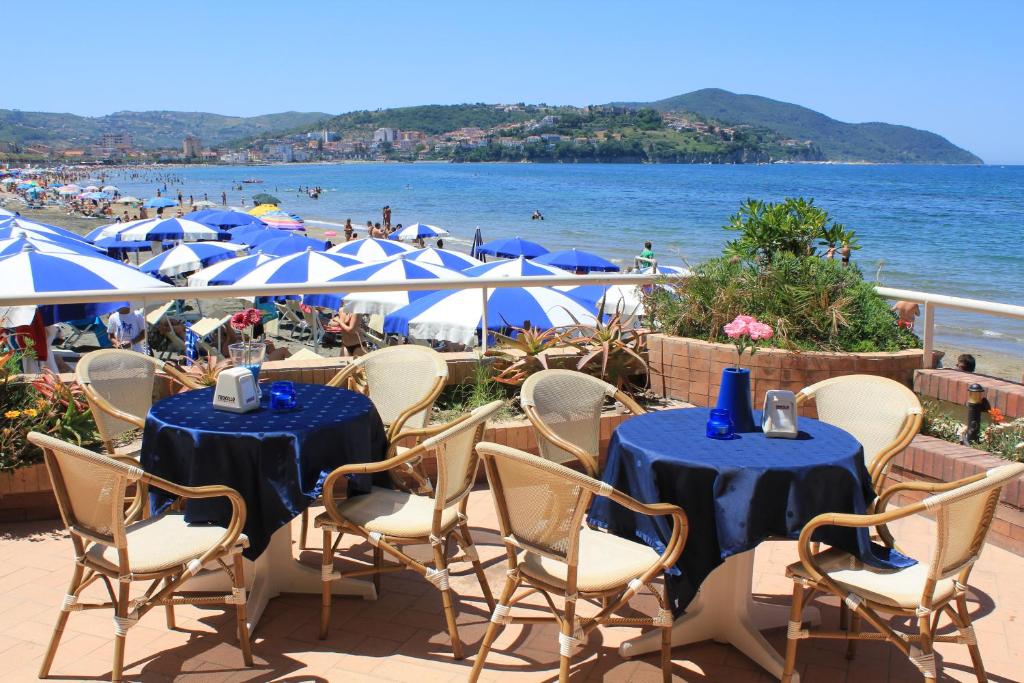 a group of tables and chairs with a view of the beach at Hotel Residence La Darsena in Agropoli