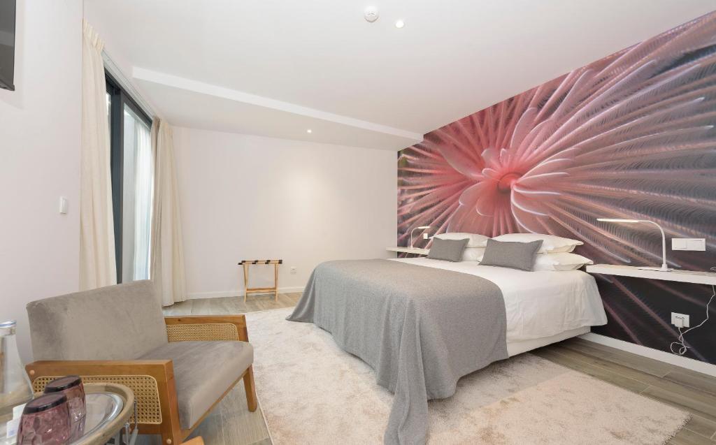 a bedroom with a bed and a large painting on the wall at Estoril Village Guest House in Estoril