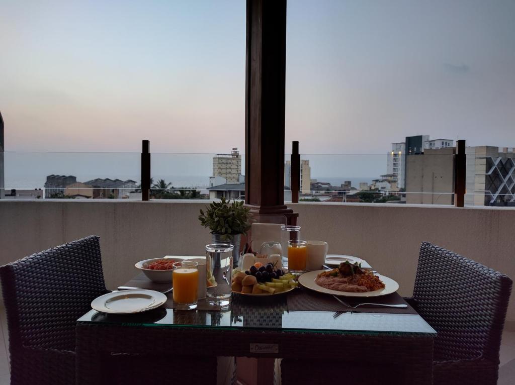 una mesa con platos de comida y zumo de naranja en The Residence, en Colombo