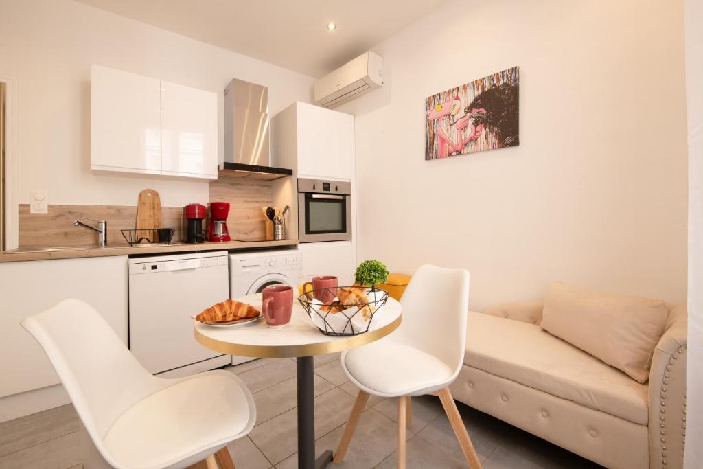 une cuisine et un salon avec une table et des chaises dans l'établissement cœur historique de cannes entre palais et mer, à Cannes