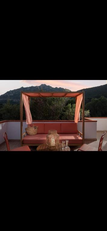 a red couch sitting under a gazebo at casa vacanza La Collina in Cugnana Verde