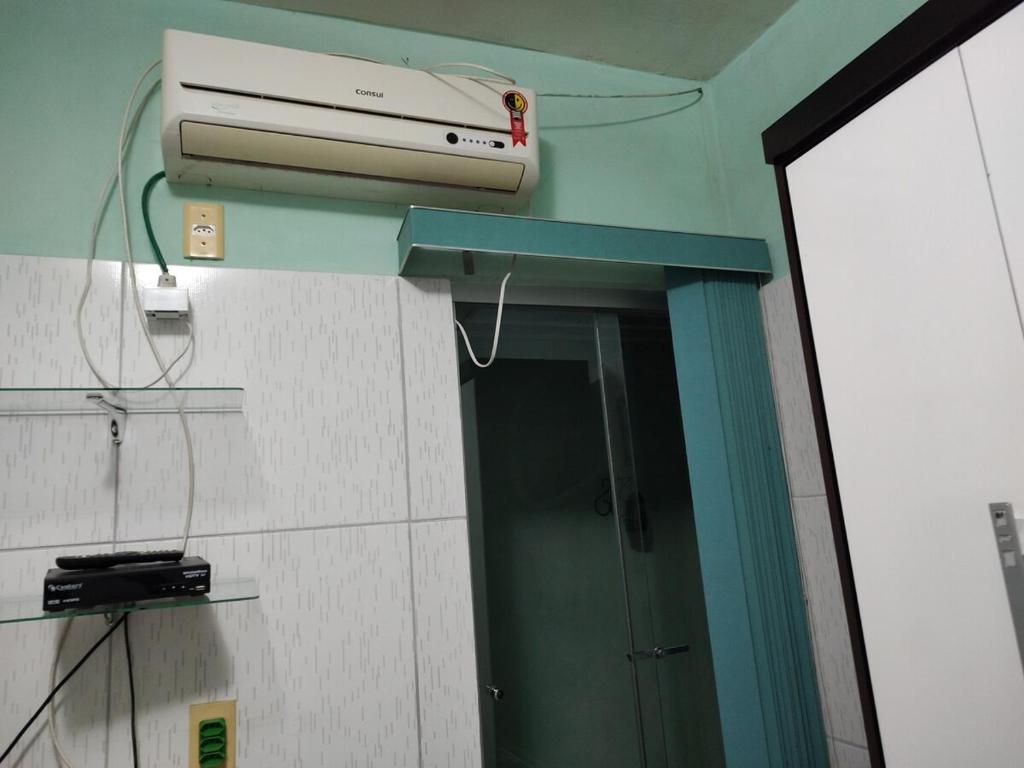 een kamer met een spiegel en airconditioning aan de muur bij Casa aconchegante! in Petrolina