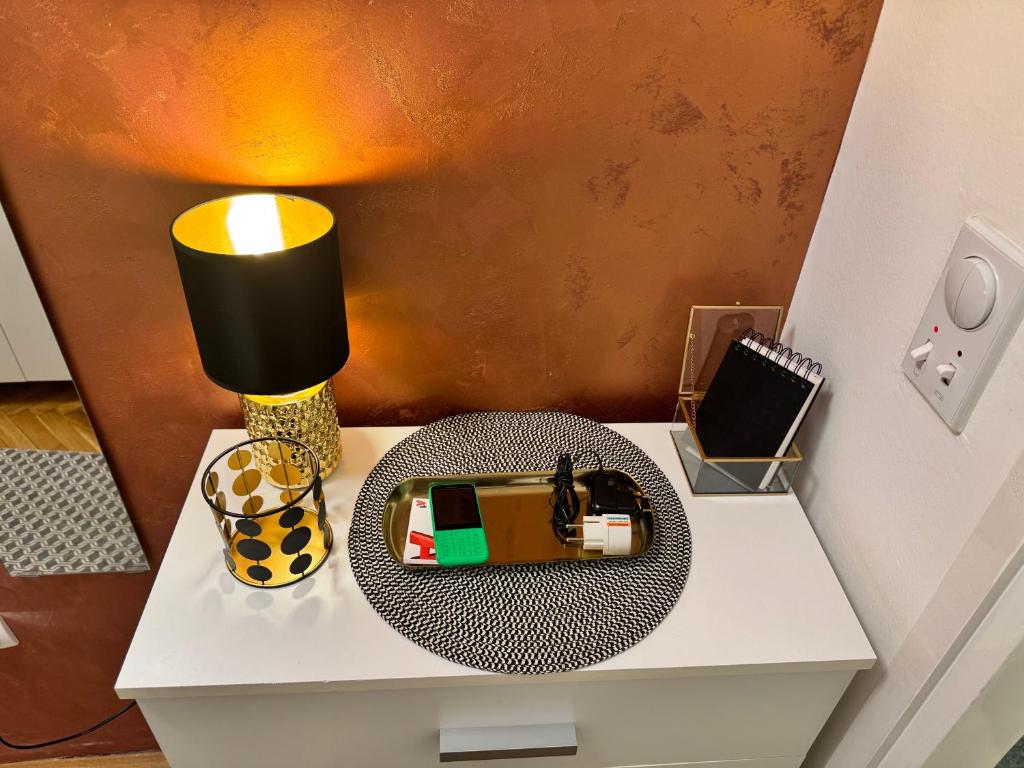 un tavolo con una lampada e una casetta giocattolo sopra di Dream Home a Sombor