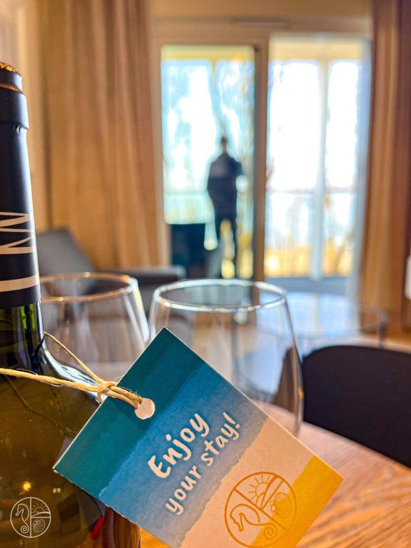 a bottle of wine and two glasses on a table at Apartament na wydmie - Perłowa Przystań in Sianozety