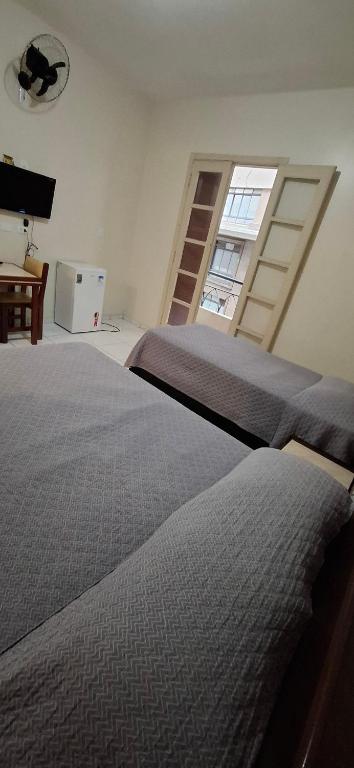 a bedroom with a large bed and a window at Hotel Plaza Olido in Sao Paulo