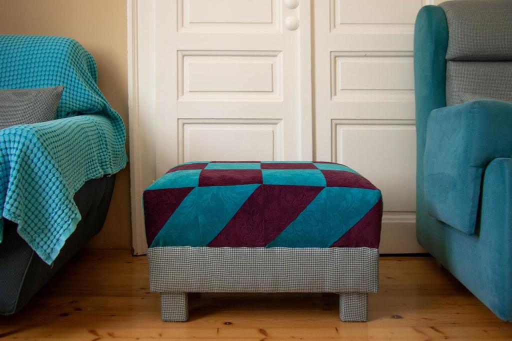 a colorful foot stool in front of a door at Apartment By the River in Niš