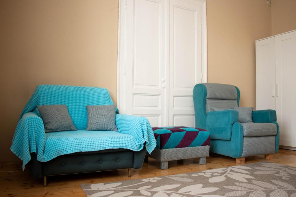 a living room with two chairs and a chair at Apartment By the River in Niš