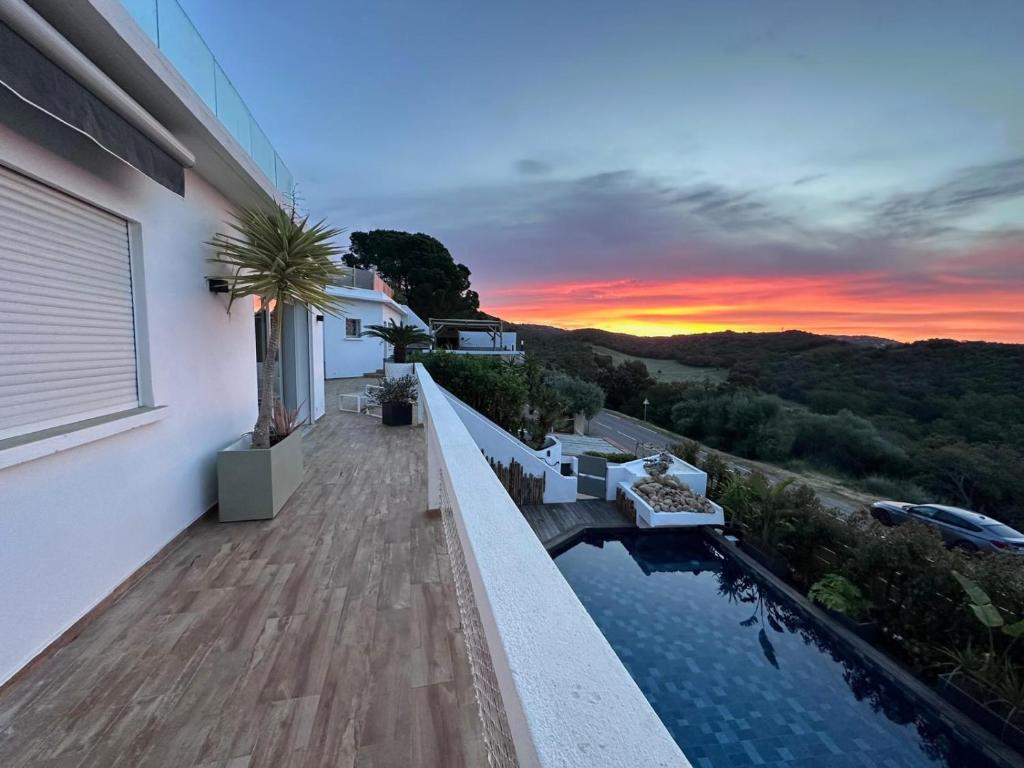 une maison avec une piscine et un coucher de soleil dans l'établissement Villa 