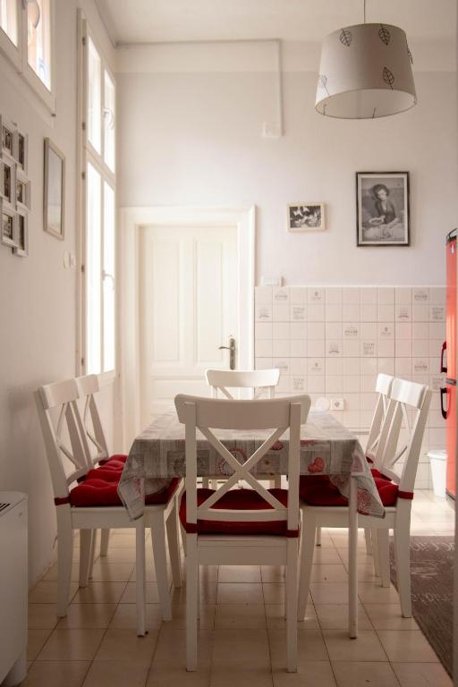 a white dining room with a table and two chairs at Apartment By the River in Niš