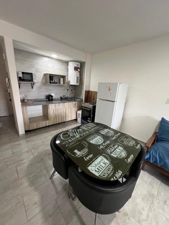 a living room with a table and a refrigerator at Estudio Playa in Miramar