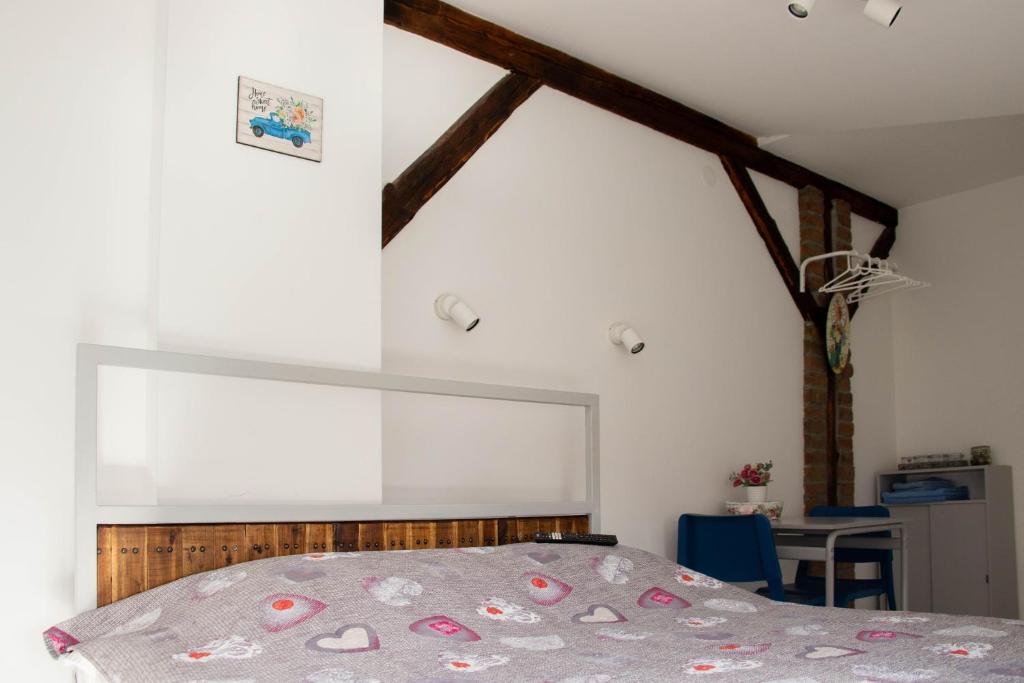 a bedroom with a bed and a table in a room at Apartment By the River in Niš