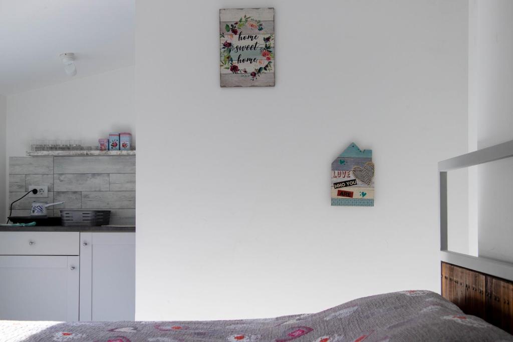 a white kitchen with a bed and a counter at Apartment By the River in Niš