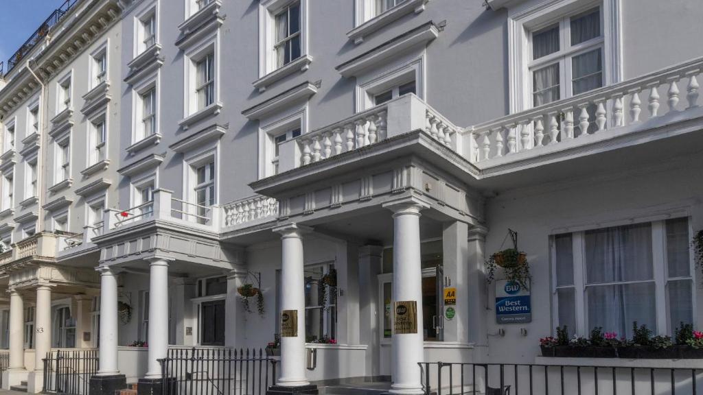 a white building with white columns and balconies at Best Western Corona Hotel in London