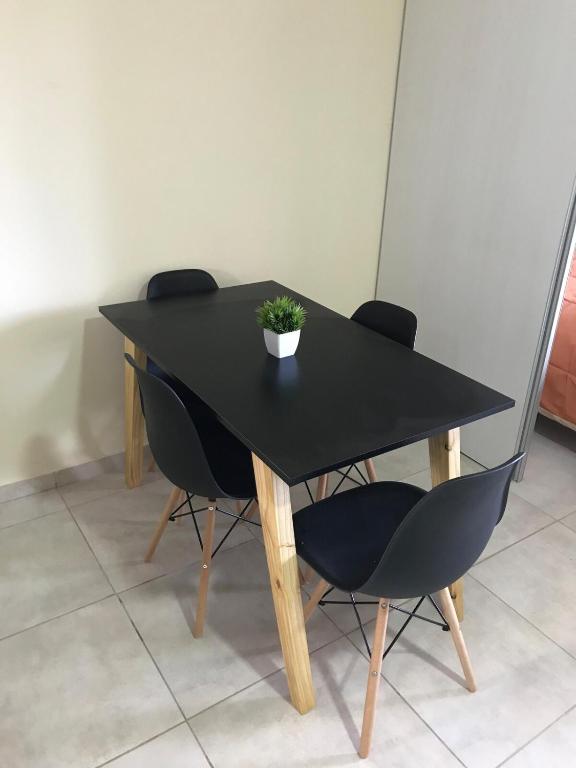 a black table with chairs and a potted plant on it at Paola in Trelew