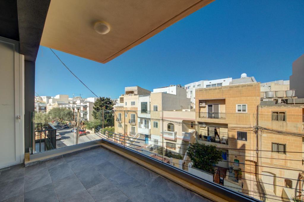 a large balcony with a view of a city at Kuya Suites by Haven and Keys Malta in Is-Swieqi