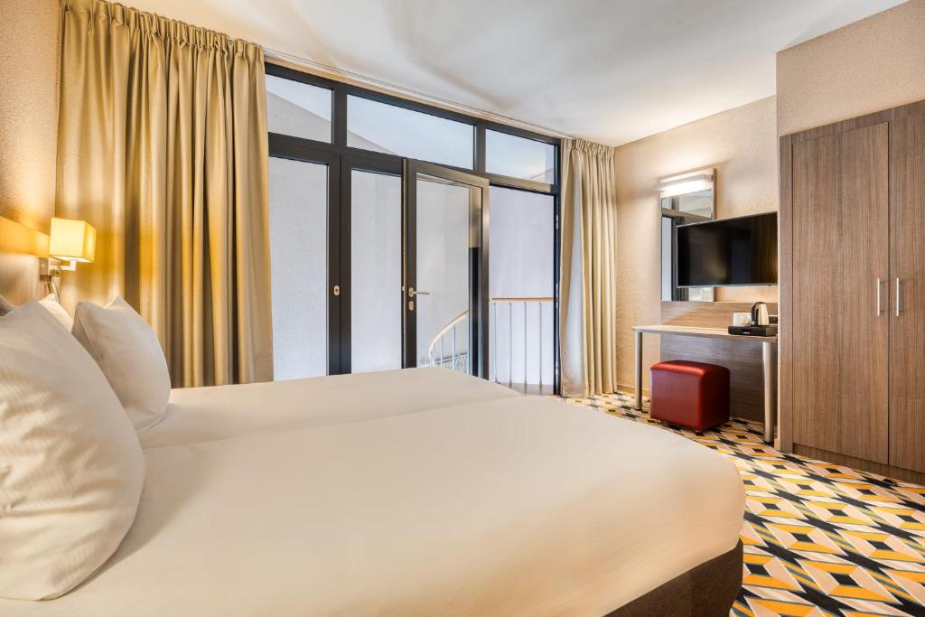 Postel nebo postele na pokoji v ubytování Alma Grand Place Hotel
