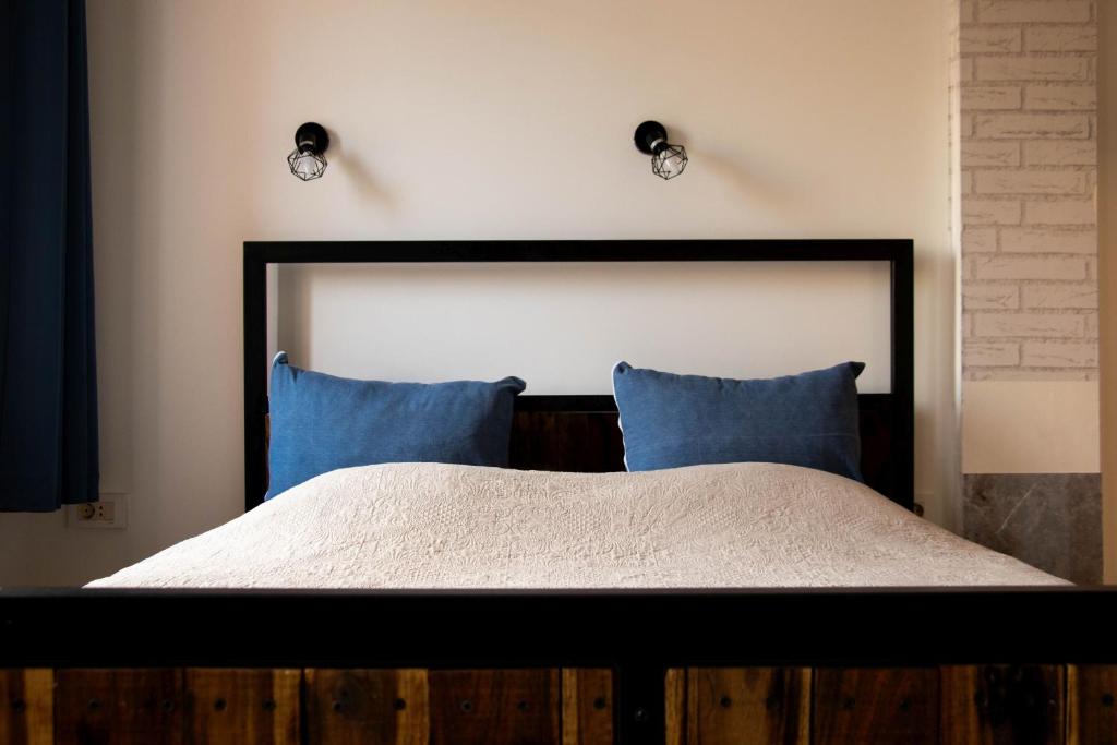 a bedroom with a large bed with blue pillows at Apartment By the River in Niš