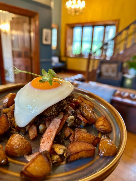 a plate of food with an egg on top at Parc-Le-Breos House in Penclawdd