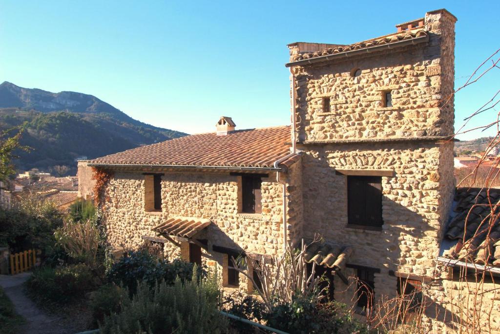 an old stone building with a mountain in the background at La maison Madeleine in Nyons