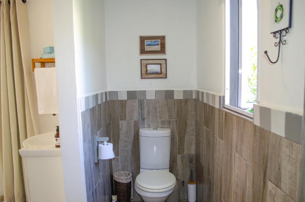 a bathroom with a toilet and a sink and a window at Hermanus Josh in Hluhluwe