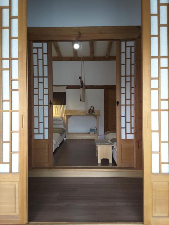 eine offene Tür zu einem Zimmer mit einem Schlafzimmer in der Unterkunft Yettle Hanok Stay in Gyeongju
