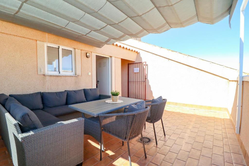 a patio with a couch and a table and chairs at Casa Joek in Los Alcázares