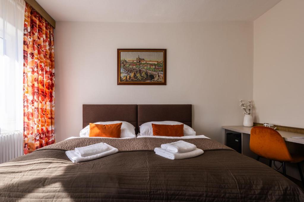 a bedroom with a bed with towels on it at Retro Hotel JISKRA in Čeladná