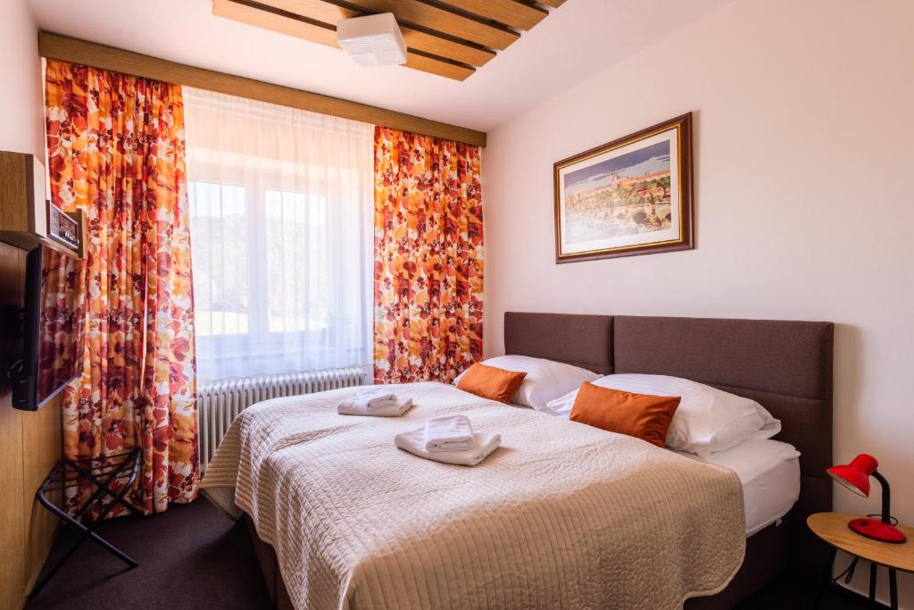 a hotel room with a bed and a window at Retro Hotel JISKRA in Čeladná