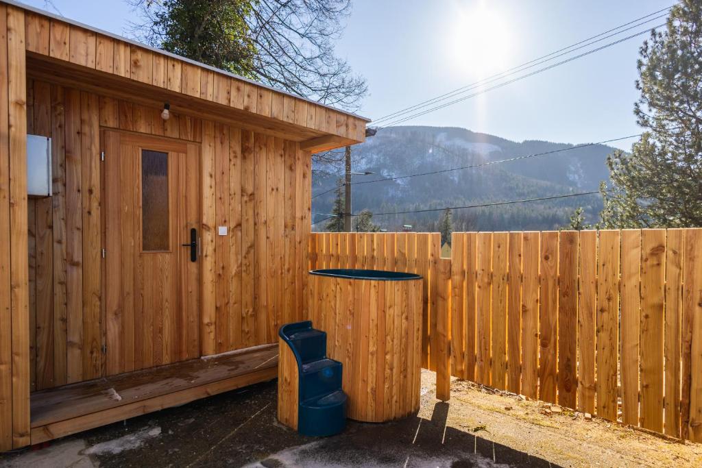 a wooden building with a table in front of a fence at Retro Hotel JISKRA in Čeladná