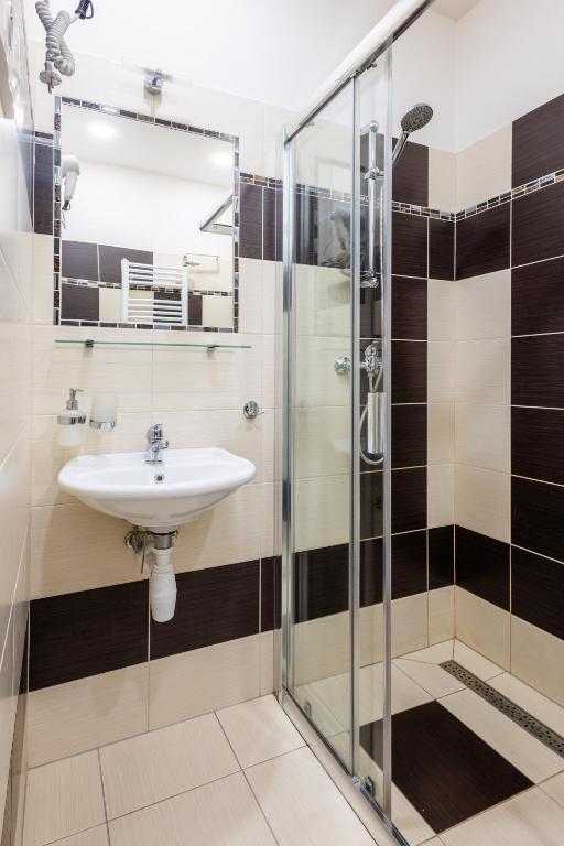 a bathroom with a sink and a shower at Retro Hotel JISKRA in Čeladná