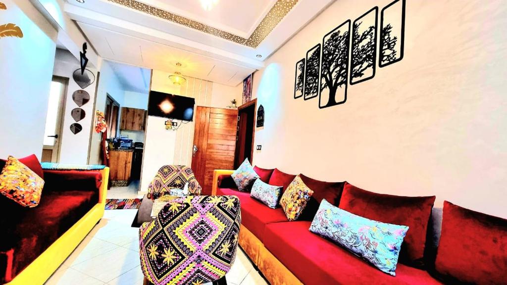 een woonkamer met een rode bank en kussens bij Apprt Ennakhil 3 in El Jadida