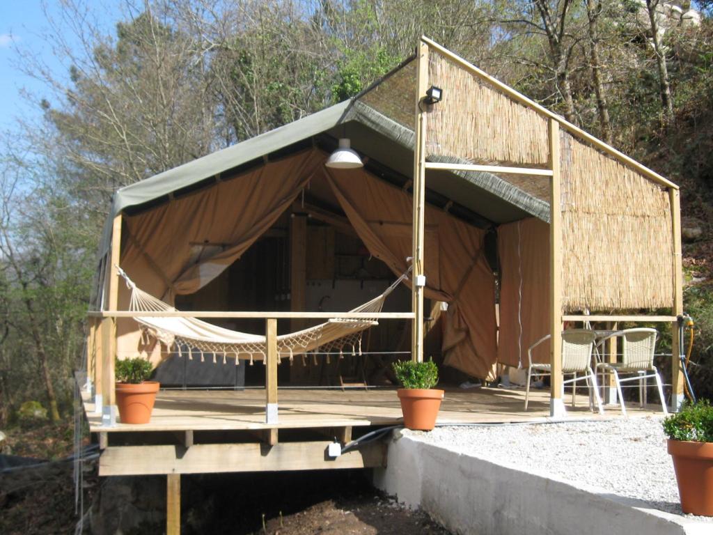 a tent with a hammock on a patio at African Tent in Ponte da Barca