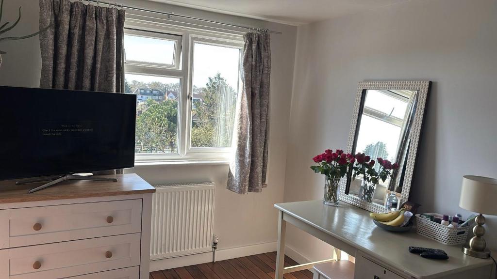 a living room with a television on a dresser and a window at Beautiful Property Close To London in Potters Bar