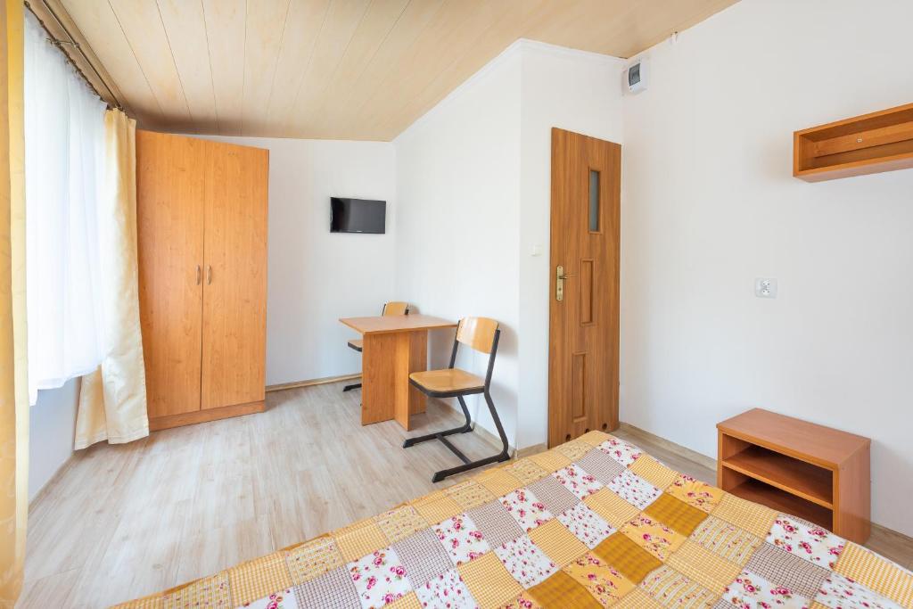 a bedroom with a bed and a desk at Domki Leśne Uroczysko in Ustka