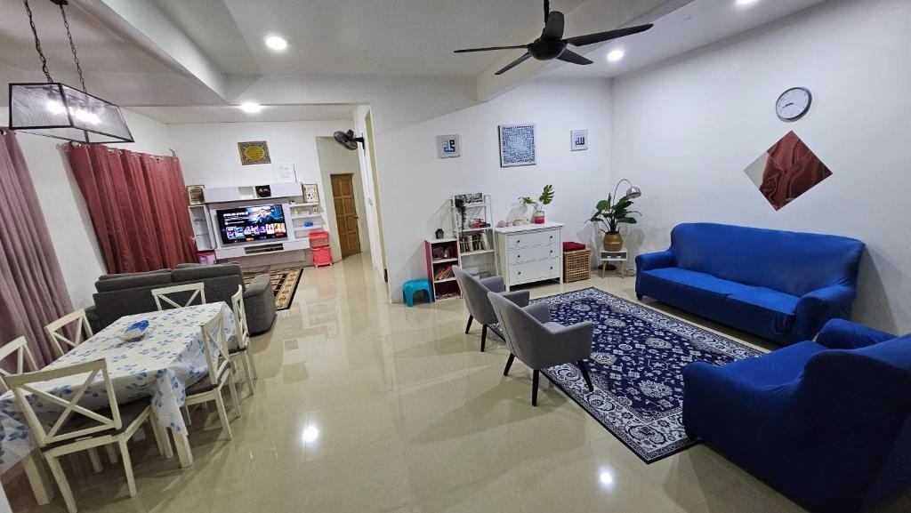 a living room with a blue couch and a table at Homestay ZaraMelly Kuala Terengganu in Kuala Terengganu