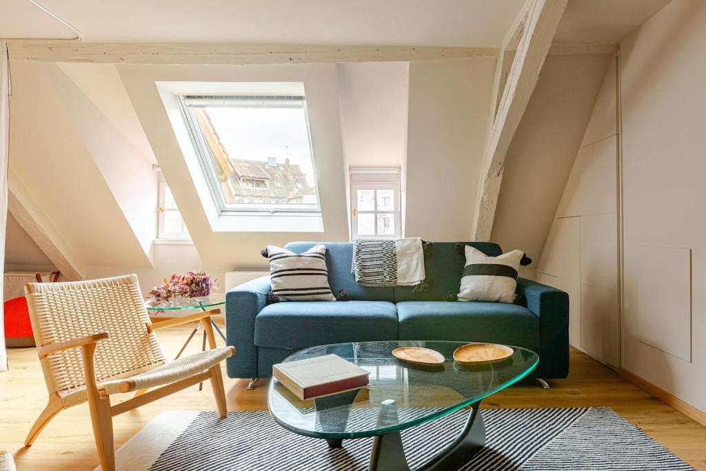 un salon avec un canapé bleu et une table en verre dans l'établissement STRAS'LOFT - Hypercentre - Haut de Gamme - Cathédrale - Confort - Calme, à Strasbourg