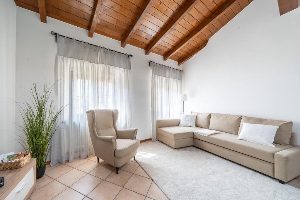una sala de estar con un sofá y una silla en Gardastay - Ferdi's House, en Riva del Garda