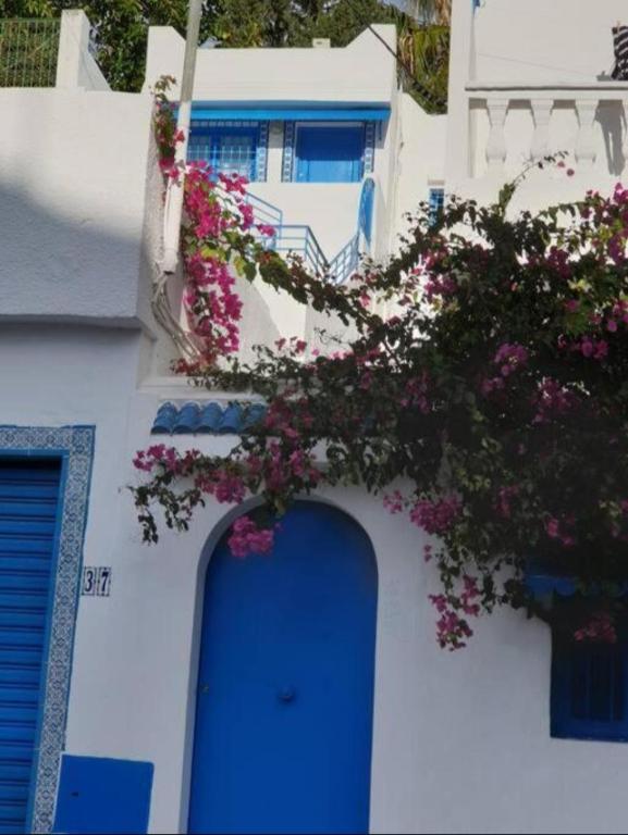 a white building with flowers on the side of it at Hammamet Studio Hafsya in Hammamet