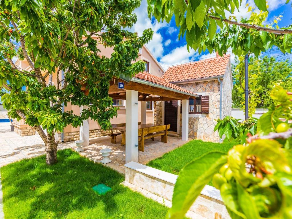 una casa con un banco en un patio en Modern Escape with Private Pool Sauna Game Room BBQ near Zadar, en Zadar