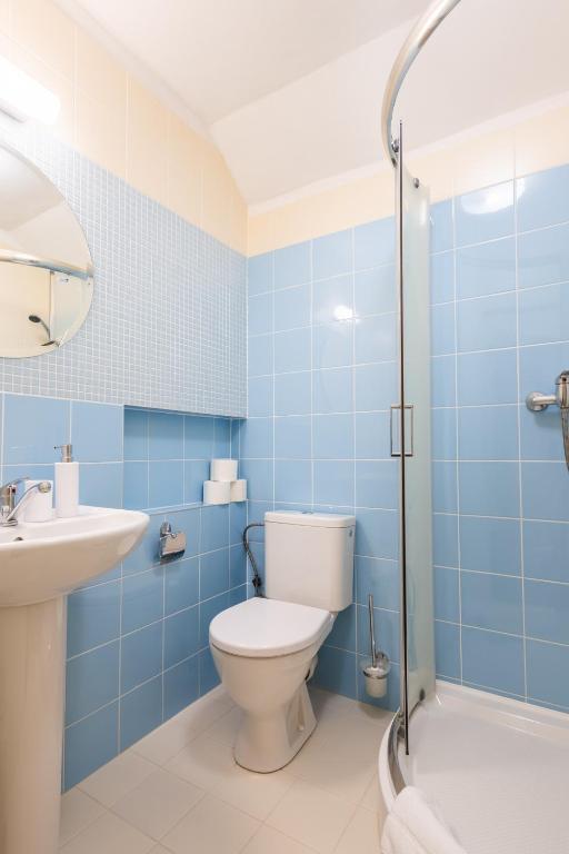 a blue bathroom with a toilet and a sink at Retro Hotel JISKRA in Čeladná