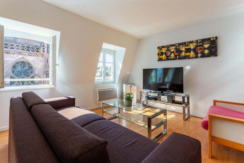 un salon avec un canapé et une télévision dans l'établissement Evasion Cathédrale, à Strasbourg