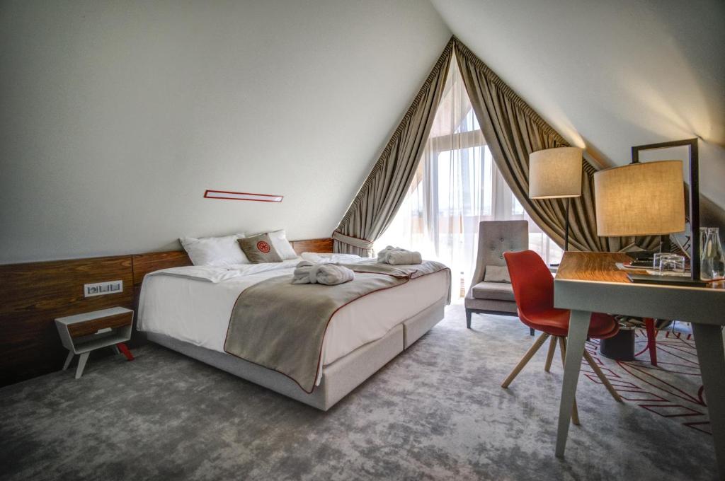 a hotel room with a bed and a desk and a desk at Hotel Kopieniec Fizjo- Med & SPA in Murzasichle
