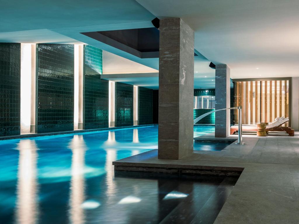 a swimming pool in a building with blue water at La Fondation in Paris